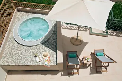 an overhead view of a pool with chairs and an umbrella at Zeus Dolce by Wyndham Athens in Vravrona