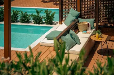 a patio with a couch and a swimming pool at Zeus Dolce by Wyndham Athens in Vravrona