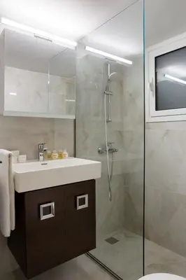 a bathroom with a sink and a glass shower at Warm & Coozy Residence in Athens