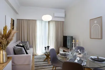 a living room with a dining table and a living room with a couch at Warm & Coozy Residence in Athens