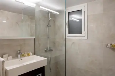 a bathroom with a glass shower and a sink at Warm & Coozy Residence in Athens