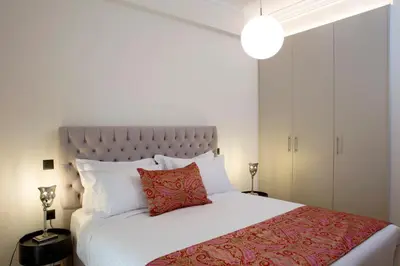 a bedroom with a white bed with a red pillow at Warm & Coozy Residence in Athens