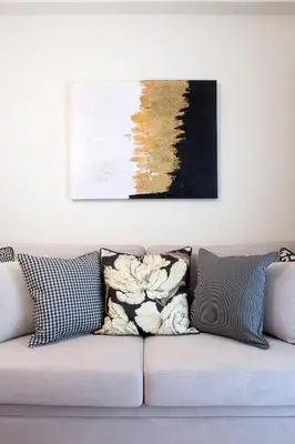 a couch with pillows and a painting on the wall at Warm & Coozy Residence in Athens