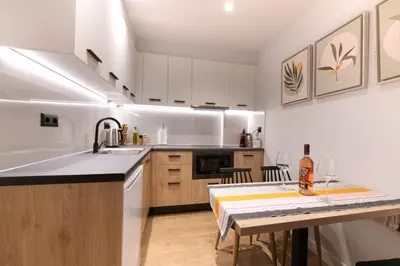 a kitchen with white cabinets and a sink and a table at A&N Athens Luxury Apartments - Ermou in Athens
