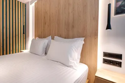 a bed with white sheets and pillows in a room at A&N Athens Luxury Apartments - Ermou in Athens