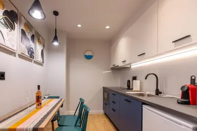 a kitchen with white cabinets and a counter with chairs at A&N Athens Luxury Apartments - Ermou in Athens