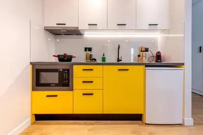 a kitchen with yellow cabinets and a microwave at A&N Athens Luxury Apartments - Ermou in Athens