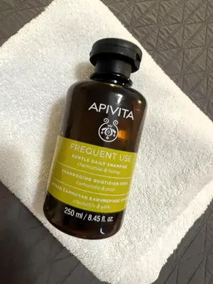 a bottle of apothecary liquid sitting on a towel at Metropolis A3 -Άνετη σουίτα in Athens