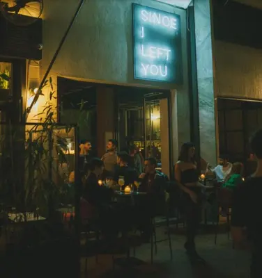 a group of people sitting at a restaurant at night at Metropolis A3 -Άνετη σουίτα in Athens