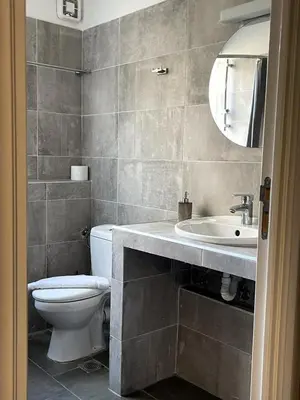a bathroom with a toilet and a sink and a mirror at Metropolis A3 -Άνετη σουίτα in Athens