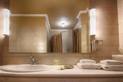 a bathroom with a sink and a mirror and towels at Galaxy Hotel in Athens