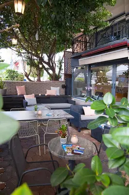 a patio with couches and tables and chairs at Galaxy Hotel in Athens