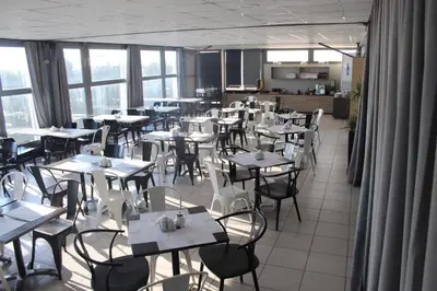 a dining room with tables and chairs and windows at Galaxy Hotel in Athens