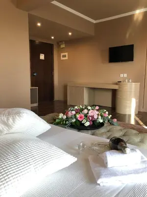 a bedroom with a bed with a bouquet of flowers at Galaxy Hotel in Athens
