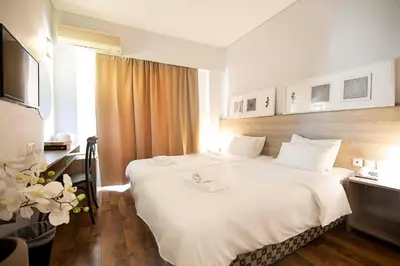 a hotel room with a bed and a television at Galaxy Hotel in Athens