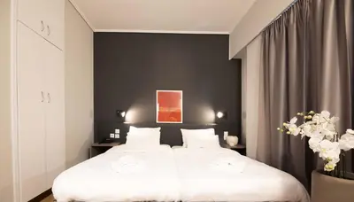 a bedroom with a white bed and a black wall at Galaxy Hotel in Athens