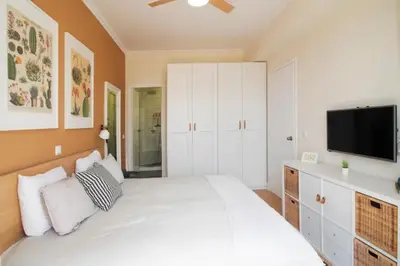 a bedroom with a white bed and a flat screen tv at Pericles Penthouse *Parthenon View* Center in Athens