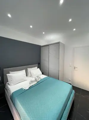 a bedroom with a large bed with a blue blanket at ATH-Brand new 2bedroom apartment in Athens