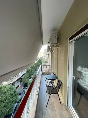 a balcony with a table and plants on a building at ATH-Brand new 2bedroom apartment in Athens