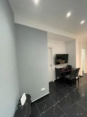 a living room with a table and chairs and a wall at ATH-Brand new 2bedroom apartment in Athens