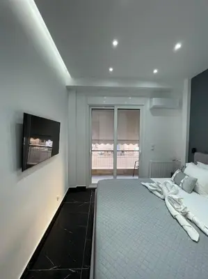 a bedroom with a large bed and a flat screen tv at ATH-Brand new 2bedroom apartment in Athens
