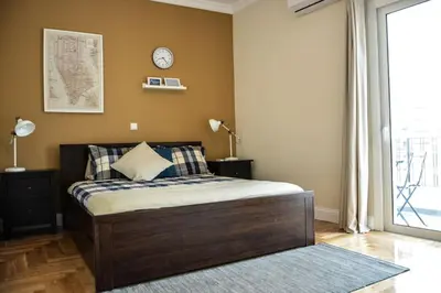 a bedroom with a bed and a clock on the wall at The Parthenon Terrace ReNoVaTeD with a view ! in Athens