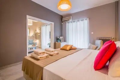 a bedroom with a large bed with red pillows on it at Glyfada's Central Apartment in Athens