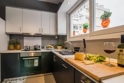 a kitchen with a counter with a glass of wine at Glyfada's Central Apartment in Athens