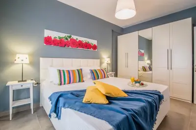 a bedroom with a white bed with a blue blanket at Glyfada's Central Apartment in Athens