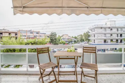 a table and two chairs on a balcony with a view at Glyfada's Central Apartment in Athens