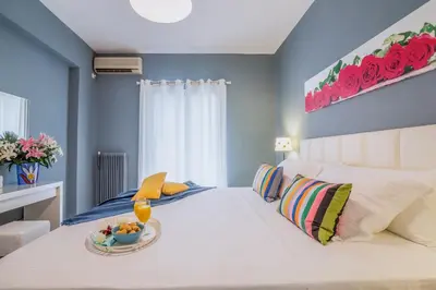 a bedroom with a white bed with a bowl of fruit on it at Glyfada's Central Apartment in Athens
