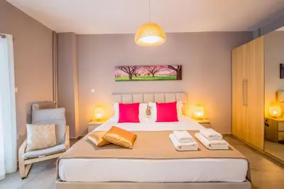 a bedroom with a large bed with pink and orange pillows at Glyfada's Central Apartment in Athens