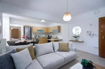 a living room with a couch and a kitchen at Pame Rentals - Cozy Glyfada Stay with Free Parking in Athens
