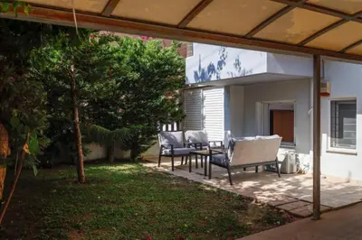 a patio with two chairs and a table in a yard at Pame Rentals - Cozy Glyfada Stay with Free Parking in Athens