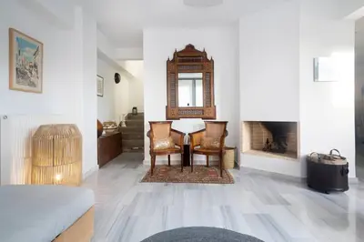 a living room with a table and chairs and a mirror at The Parthenon View in the Historical Center! in Athens