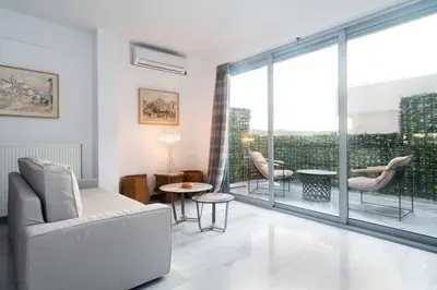a living room with a couch and a balcony at The Parthenon View in the Historical Center! in Athens