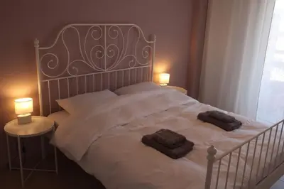 a white bed with two pillows on it with two lamps at Apartment_41 in Athens