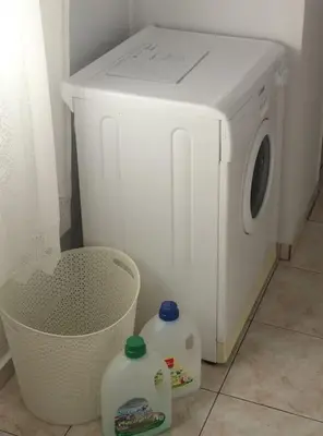 a white washing machine with two milk bottles next to it at Apartment_41 in Athens
