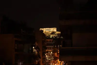 a lit up building in the middle of a city at night at Apartment_41 in Athens