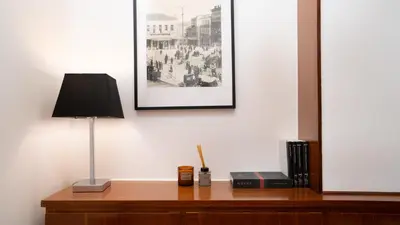 a desk with a lamp and a picture on a wall at Quiet City Center Apt on a Pedestrian Street in Athens
