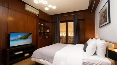 a bedroom with a bed and a flat screen tv at Quiet City Center Apt on a Pedestrian Street in Athens