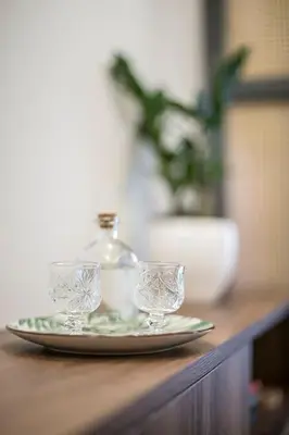 two glasses on a plate with a bottle on a table at Athens Luxury Rooms I in Athens