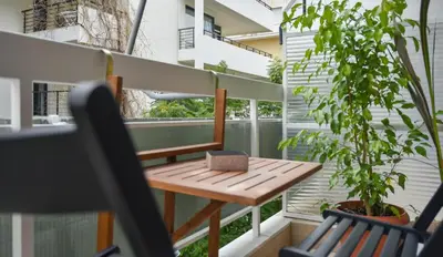 a wooden table on a balcony with a plant at 2bedroom Renovated Apartment in Athens