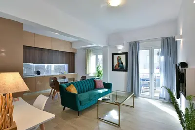 a living room with a green couch and a kitchen at 2bedroom Renovated Apartment in Athens