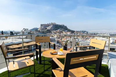 a table and chairs on a balcony with a view at Majestic Penthouse Acropolis in Athens