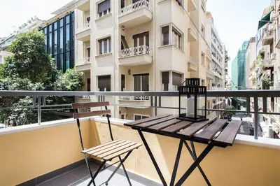 a balcony with a wooden table and a chair at Athena's Nest- *best Location* A/C +HEAT! in Athens