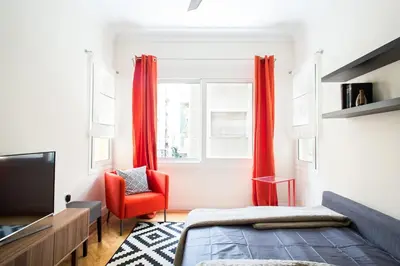 a bedroom with red curtains and a red chair at Athena's Nest- *best Location* A/C +HEAT! in Athens