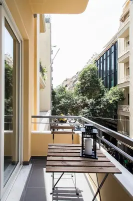 a balcony with a wooden table on a balcony at Athena's Nest- *best Location* A/C +HEAT! in Athens