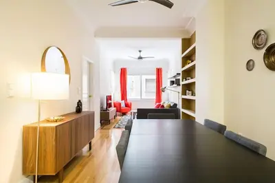 a living room with a dining table and a living room with red chairs at Athena's Nest- *best Location* A/C +HEAT! in Athens