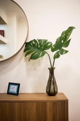 a vase sitting on top of a wooden cabinet with a plant at Athena’s Hideaway- Fully Renovated- Absolute Best Location in Athens